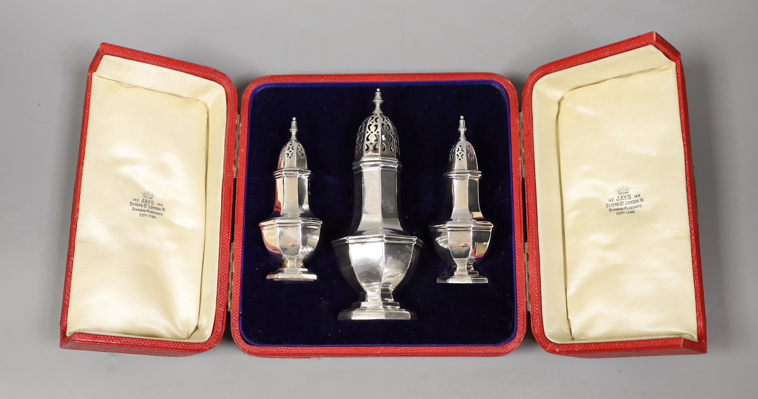 A cased Edwardian three piece pepperette and sugar caster set, by Jay, Richard Attenborough & Co, Chester 1909, caster, 12.7cm, 3.6oz.